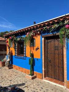 Villamayor de CamposCasa del Trotamundos的蓝色和橙色的房子,有门和鲜花