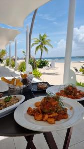 圣佩德罗-德马科里斯Exclusivo apartamento frente al mar的海滩上一张桌子,上面有三盘食物