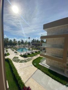 圣佩德罗-德马科里斯Exclusivo apartamento frente al mar的享有带游泳池和棕榈树的建筑的景致