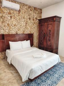 梅里达Boutique Casa Azuli Santiago的一间卧室配有一张大床和木制床头板