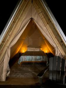 塔拉迪加Bohamia - Cozy A-Frame Glamp on 268 acre forest retreat的帐篷内的卧室,配有一张床