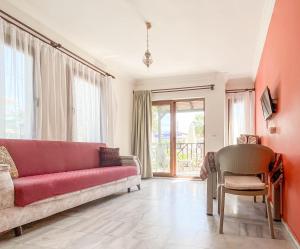 达利安Loya Vita Hotel的客厅配有红色的沙发和椅子