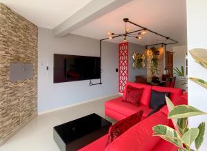 特拉曼达伊Tropical Tramandaí的客厅配有红色沙发和电视