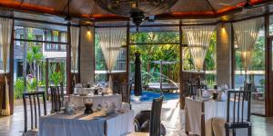 吉隆坡Villa Samadhi by Samadhi - Adults Only的餐厅设有白色的桌椅和窗户。