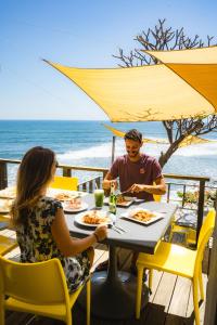 拉利伯塔德德玛别墅酒店的坐在餐桌旁吃海滩的男人和女人