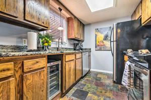 温泉城Sunset-View Resort Condo on Lake Hamilton!的厨房配有木制橱柜和黑色冰箱。