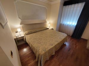 罗卡圣焦万尼美第奇别墅酒店的一间小卧室,卧室内配有一张床铺