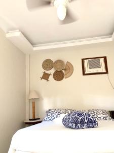 萨夸雷马Pousada OCEAN的卧室配有床和挂在墙上的帽子