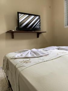 新艾朗Casa Bouganville的卧室配有一张床铺,墙上配有电视
