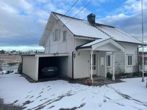 NøtterøyGamle huset på landet的雪地里带车库的白色房子