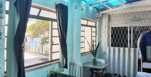 阿雷格里港Arco Iris Guest House的蓝色的客房设有窗户和桌子
