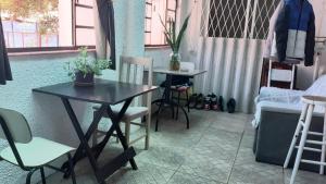 阿雷格里港Arco Iris Guest House的一间带桌椅和沙发的用餐室