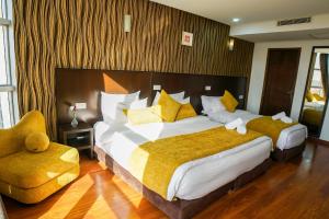 阿尤恩Sahariano hotel City Center的酒店客房配有一张带黄色枕头的大床