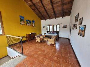 危地马拉安地瓜Amplia casa Antigua Guatemala con pérgola y jardín的客厅设有黄色的墙壁和桌椅