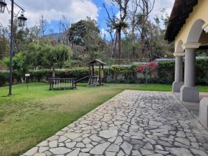 危地马拉安地瓜Amplia casa Antigua Guatemala con pérgola y jardín的庭院里的石头走道,带游乐场