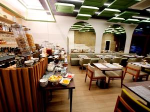 波尔图Porta Nobre - Exclusive Living Hotel的一间带桌椅的餐厅和一间酒吧