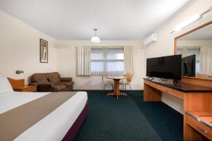 布里斯班飞马汽车旅馆及服务式公寓的配有一张床和一台平面电视的酒店客房