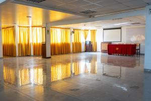 利马Hotel Perú Pacífico的大房间设有黄色窗帘和红色桌子