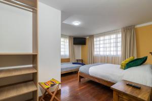 波哥大Corazon del Molino Corferias Bogota- Embajada Americana的酒店客房配有一张床、一张书桌和一张四柱床