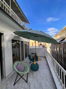 雅典Casa de Tres Hermanos in the heart of Athens的阳台配有绿伞和两把椅子