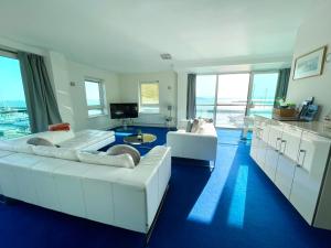 浦耳Quay & Sea View Spacious Modern Secure Parking的一间带2张白色沙发的客厅和一间厨房