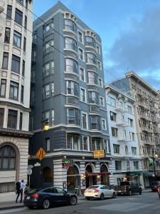 旧金山The Andrews Hotel的一条城市街道上高大的灰色建筑,有汽车
