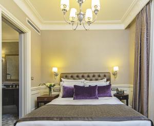 伊斯坦布尔梅洛迪巴格达缇里雅酒店的一间卧室配有一张带紫色枕头的大床