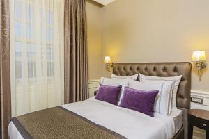伊斯坦布尔梅洛迪巴格达缇里雅酒店的一间卧室配有一张带紫色枕头的大床