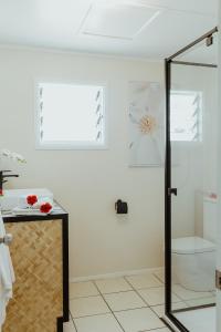阿鲁坦加Tai Roto Bay的一间带玻璃淋浴间和卫生间的浴室