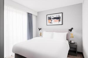布莱顿霍夫Staybridge Suites Brighton, an IHG Hotel的卧室配有白色的床和窗户。