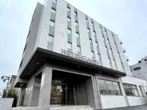 熊谷HOTEL GLANY's KUMAGAYA - Vacation STAY 27267v的一座高大的建筑,有大入口