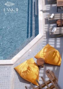 芭堤雅市中心ENNKAI Beachfront Resort Koh Larn的游泳池旁的游泳池,带两个黄色橡胶垫