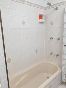 Picnic BayTurtle Cottage Magnetic Island的白色的浴室设有浴缸和淋浴。
