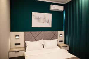 阿特劳Zodiac的一间卧室设有一张床和绿色的墙壁