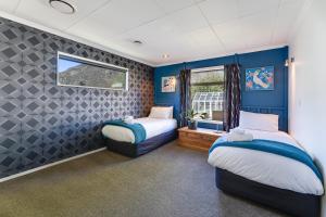 皇后镇Remarkable View 4 Bedroom的配有两张床铺的蓝色墙壁和窗户