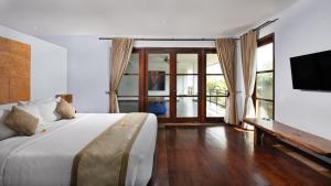 塞米亚克Danoya Private Luxury Residences的一间卧室配有一张大床和电视