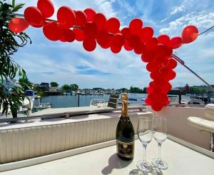 布鲁克林Romantic Condo @ Ocean 3-deck Yacht的阳台上的一瓶香槟和两杯酒