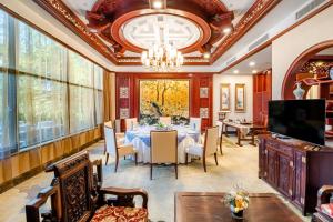 潍坊潍坊富华大酒店a座的一间带桌子和吊灯的用餐室