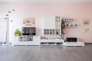 LiederbachFerienhaus Hunsrückliebe的客厅配有白色家具和平面电视
