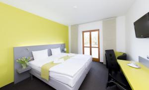 布拉格赫耳墨斯酒店的一间卧室配有一张床、一张书桌和一台电视。