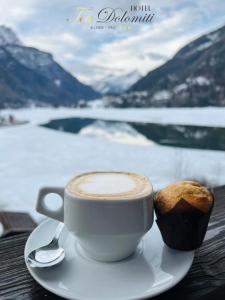 阿莱盖Hotel TEA Dolomiti的桌上的咖啡和松饼