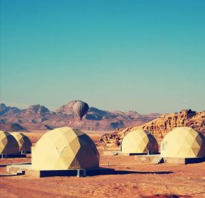瓦迪拉姆Amanda Luxury Camp的一群在沙漠中与山 ⁇ 交织的帐篷