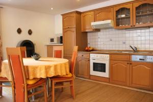 毛特Ferienwohnung Christa的厨房配有桌子、水槽和炉灶。