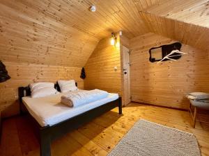 彼得罗沙尼Chalet Nomad的木制客房内的一间卧室,配有一张床