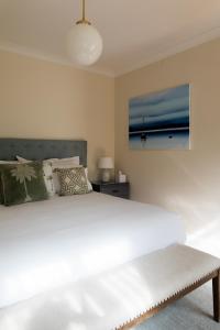 LymingtonWoodland Bay Retreat-Luxury Hamptons Retreat的卧室配有一张白色大床和一幅画