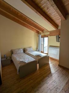 瓦尔迪耶里CONSTANCIA TRATTORIA的一间铺有木地板的客房内配有两张床的卧室