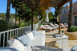 波蒂纳茨Villa Cas Puig - Beach of Portinatx的庭院里摆放着一组白色的躺椅