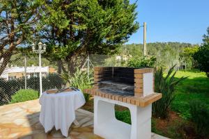 波蒂纳茨Villa Cas Puig - Beach of Portinatx的露台上的户外烧烤架和桌子