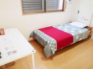 大阪大阪abc公寓的一张小床,位于带桌子的房间