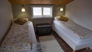 Djupavik迪居帕威客酒店的小型客房 - 带2张床和窗户